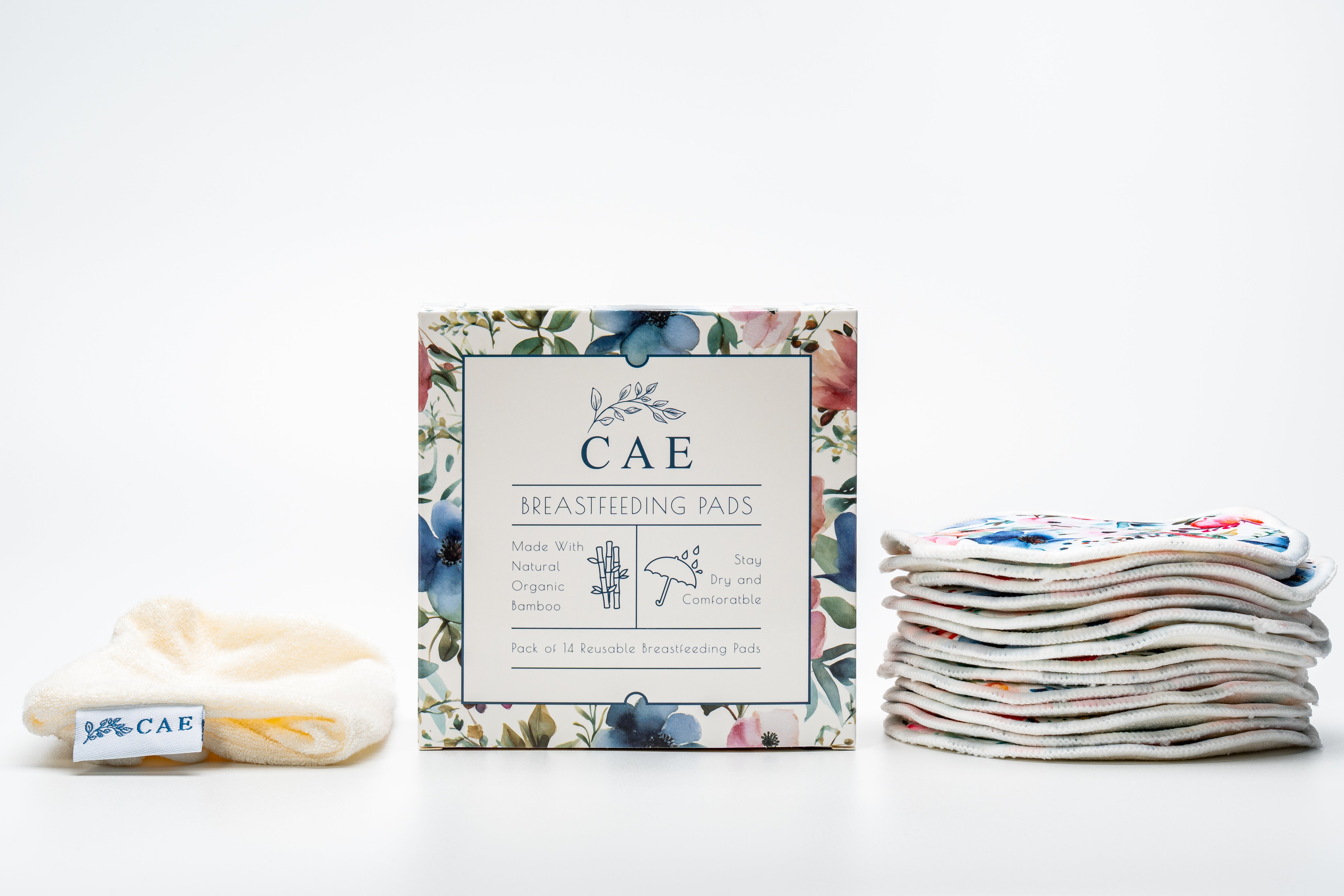 Open CAE box showing washable bamboo breast pads stacked beside it as part of the Silverette® Welcome Baby Gift Set
